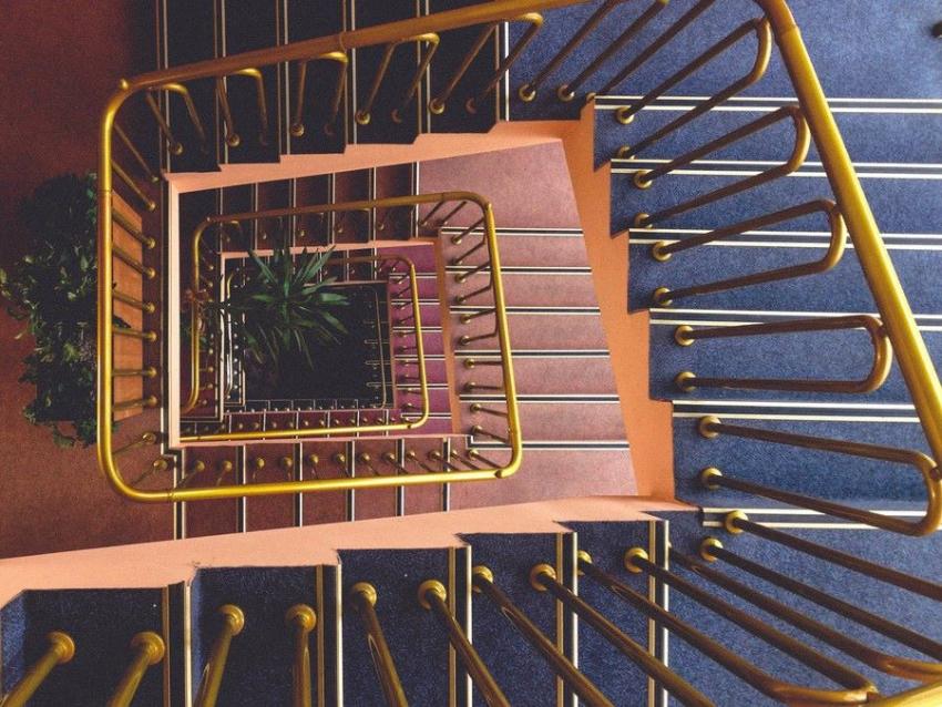 Escalera con tubo de latón en barandilla